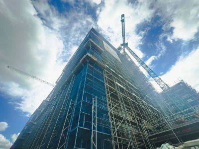Ger&uuml;st und Kran an Hochhaus-Baustelle &ndash; zeigt gro&szlig;fl&auml;chige Rohbauarbeiten bei mehrgeschossigen Geb&auml;uden